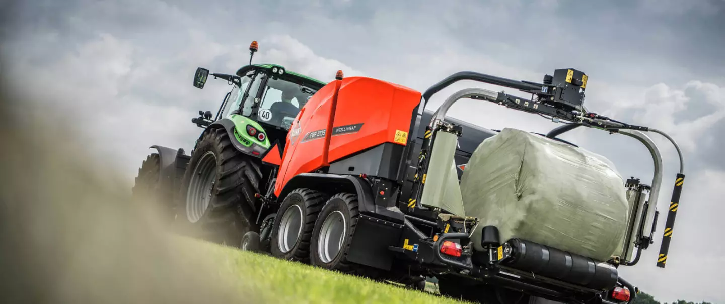 FBP 3135 wrapping a bale under a cloudy sky
