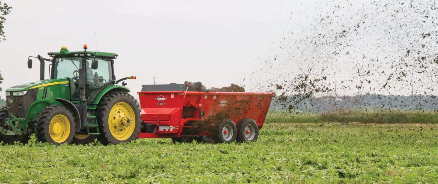 Side view of SL 124 spreading manure in a field.